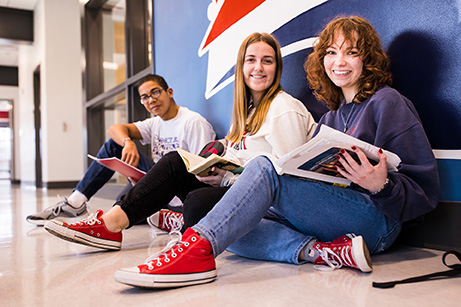 one male and two female ShipU students sitting on the floor in the CUB