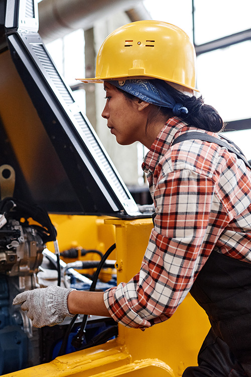 a woman of color operating heavy machinery